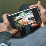 Person watching a video on a smartphone with subtitles enabled.